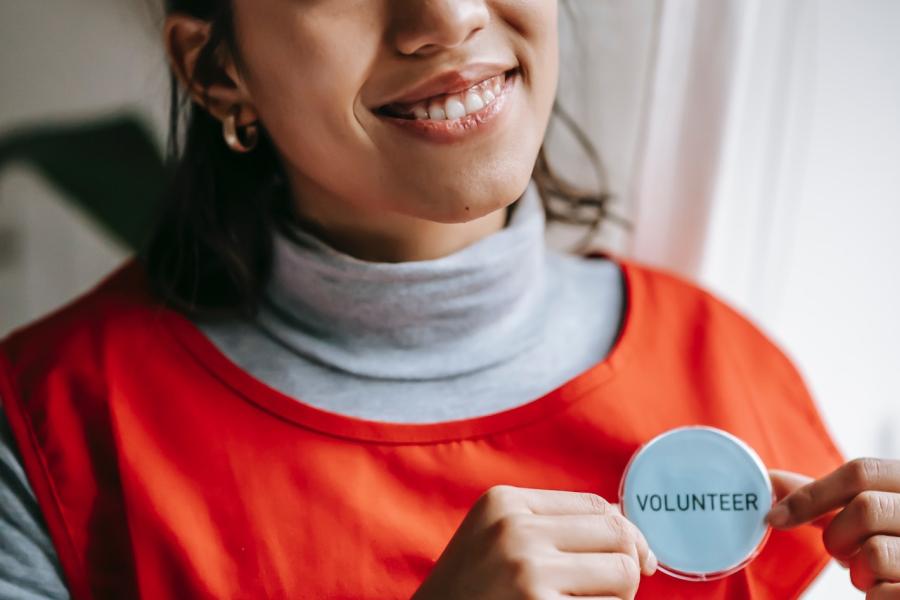 Woman showing volunteer button